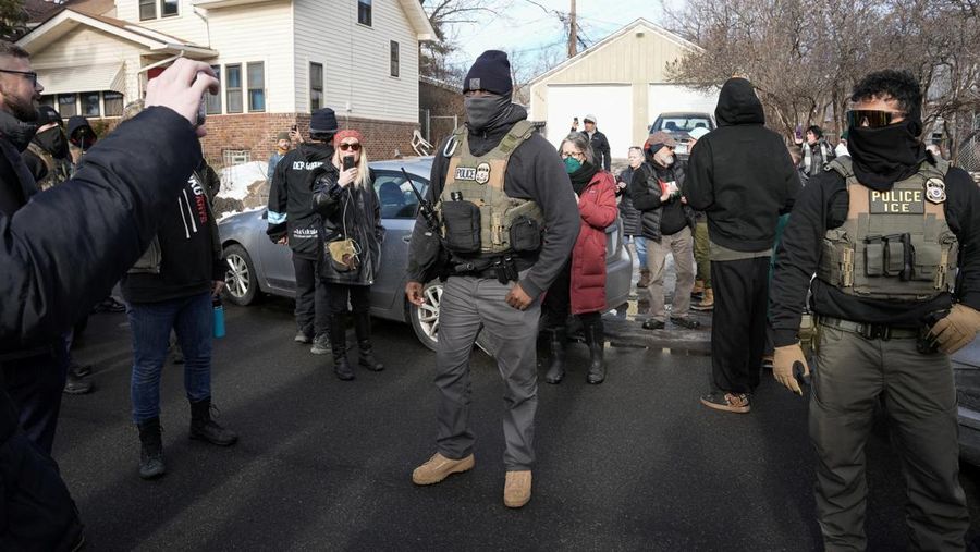 Agen Imigrasi dan Bea Cukai AS (ICE) berdiri di samping mobil warga sipil yang rusak akibat ditabrak oleh ICE, setelah seorang agen ICE menembak mati Renee Nicole Good, di Minneapolis, Minnesota, AS, 12 Januari 2026. (REUTERS/Tim Evans)