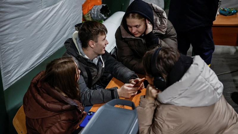 Seseorang berdiri di luar pusat Point of Invincibility, tempat perlindungan yang dikelola pemerintah yang menawarkan layanan dasar dan penghangat selama pemadaman listrik, di mana warga menghangatkan diri dan mengisi daya perangkat mereka, selama pemadaman listrik setelah infrastruktur sipil penting dihantam oleh serangan rudal dan drone Rusia baru-baru ini, di tengah serangan Rusia terhadap Ukraina, di Kyiv, Ukraina, 12 Januari 2026. (REUTERS/Alina Smutko)