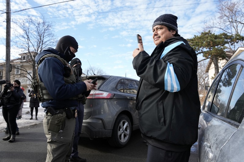 Agen Imigrasi dan Bea Cukai AS (ICE) berdiri di samping mobil warga sipil yang rusak akibat ditabrak oleh ICE, setelah seorang agen ICE menembak mati Renee Nicole Good, di Minneapolis, Minnesota, AS, 12 Januari 2026. (REUTERS/Tim Evans)