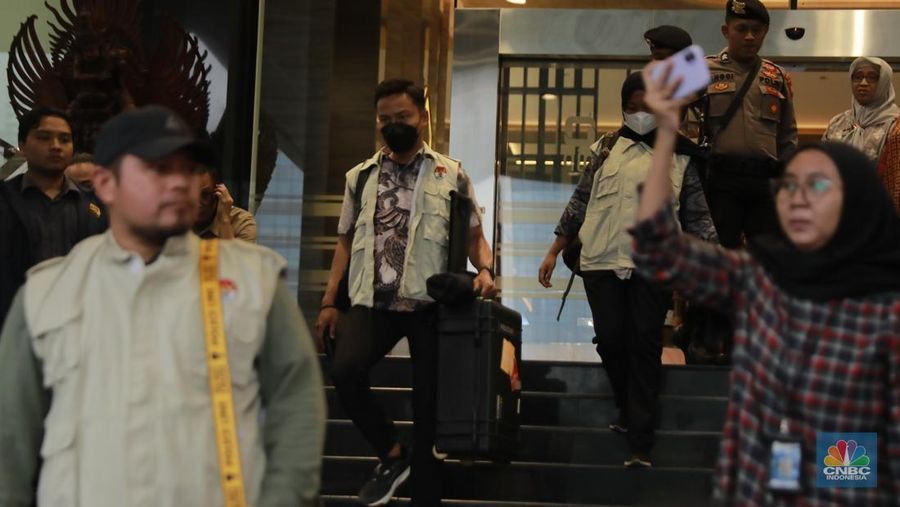 Petugas KPK membawa koper usai menggeledah kantor pusat di kantor pusat Direktorat Jenderal Pajak (DJP) Kementerian Keuangan di Jalan Gatot Subroto Jakarta Selatan, Selasa (13/1/2026). (CNBC Indonesia/Muhammad Sabki)