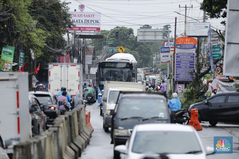 Sejumlah kendaraan melewati Jalan Raya Sawangan, Depok, Jawa Barat, Selasa(13/1/2026). (CNBC Indonesia/Tri Susilo)