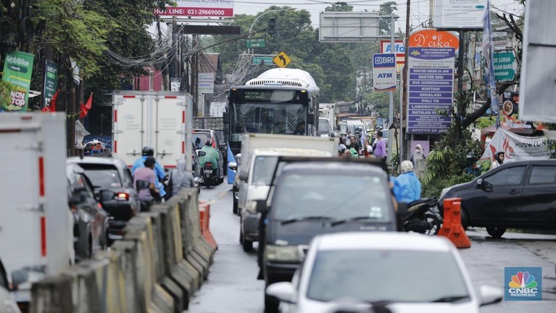 Sejumlah kendaraan melewati Jalan Raya Sawangan, Depok, Jawa Barat, Selasa(13/1/2026). (CNBC Indonesia/Tri Susilo)