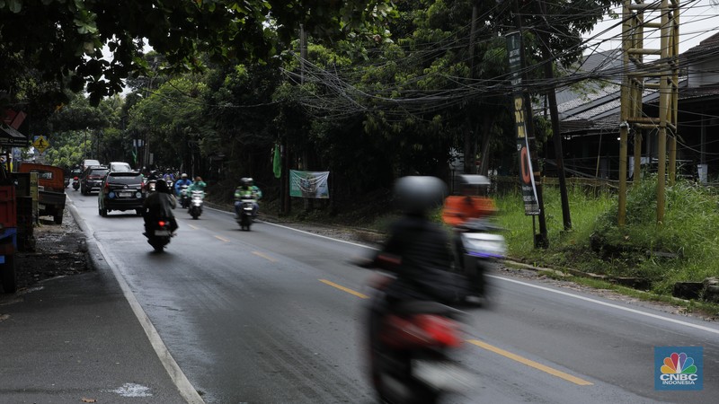 Sejumlah kendaraan melewati Jalan Raya Sawangan, Depok, Jawa Barat, Selasa(13/1/2026). (CNBC Indonesia/Tri Susilo)