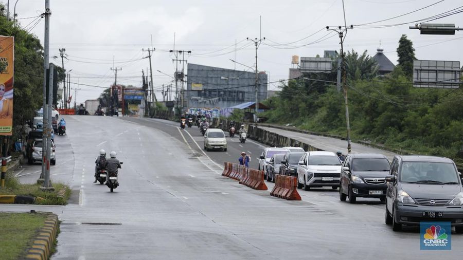 Sejumlah kendaraan melewati Jalan Raya Sawangan, Depok, Jawa Barat, Selasa(13/1/2026). (CNBC Indonesia/Tri Susilo)