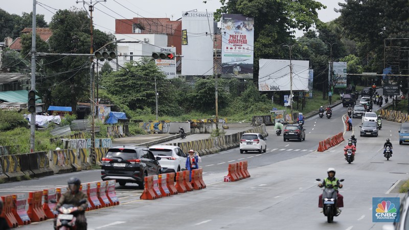 Sejumlah kendaraan melewati Jalan Raya Sawangan, Depok, Jawa Barat, Selasa(13/1/2026). (CNBC Indonesia/Tri Susilo)
