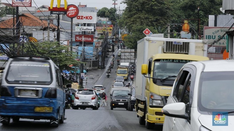 Sejumlah kendaraan melewati Jalan Raya Sawangan, Depok, Jawa Barat, Selasa(13/1/2026). (CNBC Indonesia/Tri Susilo)