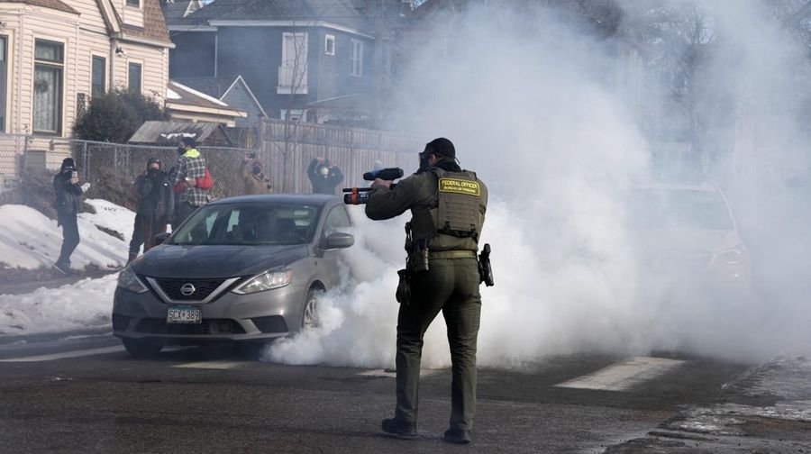 Agen Imigrasi dan Bea Cukai AS (ICE) berdiri di samping mobil warga sipil yang rusak akibat ditabrak oleh ICE, setelah seorang agen ICE menembak mati Renee Nicole Good, di Minneapolis, Minnesota, AS, 12 Januari 2026. (REUTERS/Tim Evans)
