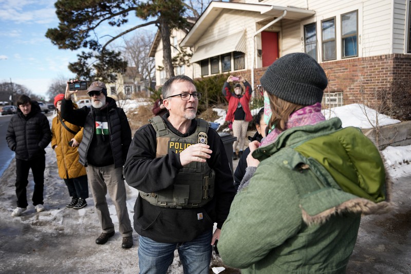 Agen Imigrasi dan Bea Cukai AS (ICE) berdiri di samping mobil warga sipil yang rusak akibat ditabrak oleh ICE, setelah seorang agen ICE menembak mati Renee Nicole Good, di Minneapolis, Minnesota, AS, 12 Januari 2026. (REUTERS/Tim Evans)