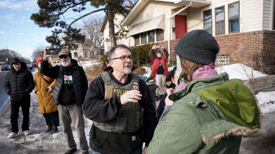 Agen Imigrasi dan Bea Cukai AS (ICE) berdiri di samping mobil warga sipil yang rusak akibat ditabrak oleh ICE, setelah seorang agen ICE menembak mati Renee Nicole Good, di Minneapolis, Minnesota, AS, 12 Januari 2026. (REUTERS/Tim Evans)