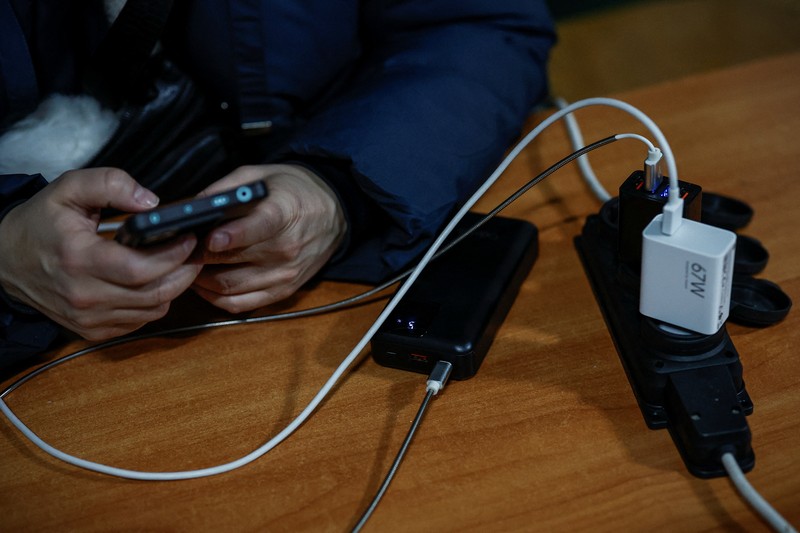 Seseorang berdiri di luar pusat Point of Invincibility, tempat perlindungan yang dikelola pemerintah yang menawarkan layanan dasar dan penghangat selama pemadaman listrik, di mana warga menghangatkan diri dan mengisi daya perangkat mereka, selama pemadaman listrik setelah infrastruktur sipil penting dihantam oleh serangan rudal dan drone Rusia baru-baru ini, di tengah serangan Rusia terhadap Ukraina, di Kyiv, Ukraina, 12 Januari 2026. (REUTERS/Alina Smutko)