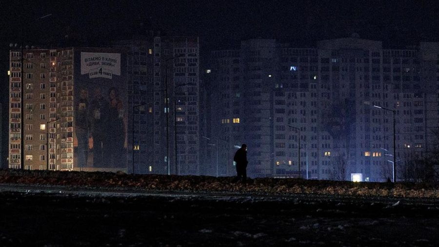 Seseorang berdiri di luar pusat Point of Invincibility, tempat perlindungan yang dikelola pemerintah yang menawarkan layanan dasar dan penghangat selama pemadaman listrik, di mana warga menghangatkan diri dan mengisi daya perangkat mereka, selama pemadaman listrik setelah infrastruktur sipil penting dihantam oleh serangan rudal dan drone Rusia baru-baru ini, di tengah serangan Rusia terhadap Ukraina, di Kyiv, Ukraina, 12 Januari 2026. (REUTERS/Alina Smutko)