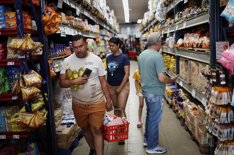 Para pembeli mengecek harga di sebuah supermarket di Villa Martelli di pinggiran Buenos Aires, Argentina, 13 Januari 2026. (REUTERS/Agustin Marcarian)