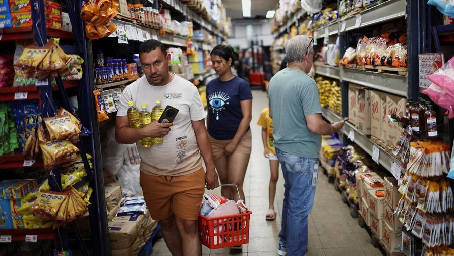 Para pembeli mengecek harga di sebuah supermarket di Villa Martelli di pinggiran Buenos Aires, Argentina, 13 Januari 2026. (REUTERS/Agustin Marcarian)