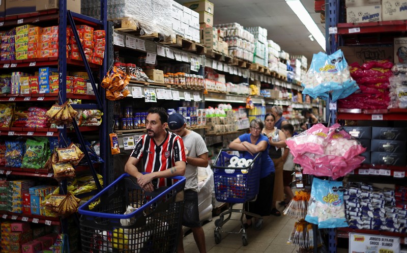 Para pembeli mengecek harga di sebuah supermarket di Villa Martelli di pinggiran Buenos Aires, Argentina, 13 Januari 2026. (REUTERS/Agustin Marcarian)