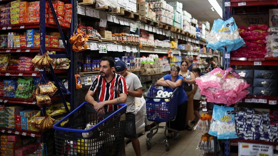 Para pembeli mengecek harga di sebuah supermarket di Villa Martelli di pinggiran Buenos Aires, Argentina, 13 Januari 2026. (REUTERS/Agustin Marcarian)
