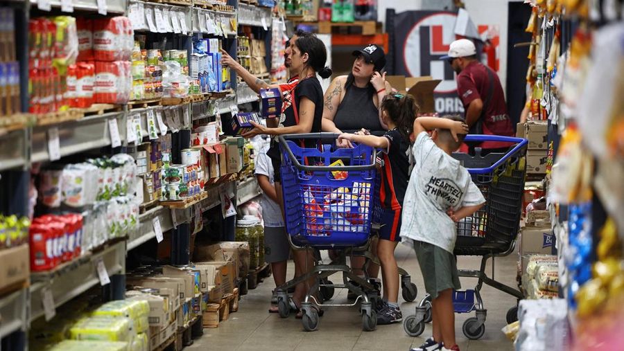 Para pembeli mengecek harga di sebuah supermarket di Villa Martelli di pinggiran Buenos Aires, Argentina, 13 Januari 2026. (REUTERS/Agustin Marcarian)