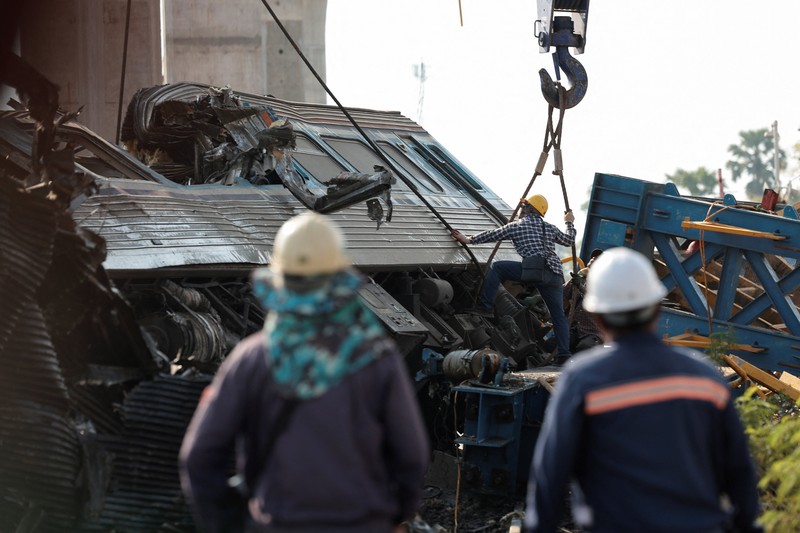 Para petugas bekerja di lokasi kecelakaan kereta api yang terjadi ketika sebuah derek konstruksi roboh dan jatuh menimpa gerbong-gerbongnya, menyebabkan beberapa korban jiwa, di distrik Sikhio, provinsi Nakhon Ratchasima, Thailand, 14 Januari 2026. (REUTERS/Chalinee Thirasupa)