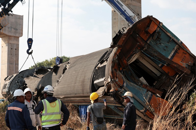 Para petugas bekerja di lokasi kecelakaan kereta api yang terjadi ketika sebuah derek konstruksi roboh dan jatuh menimpa gerbong-gerbongnya, menyebabkan beberapa korban jiwa, di distrik Sikhio, provinsi Nakhon Ratchasima, Thailand, 14 Januari 2026. (REUTERS/Chalinee Thirasupa)