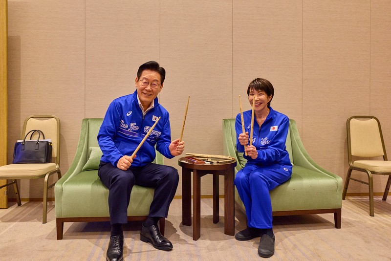 Perdana Menteri Jepang Sanae Takaichi dan Presiden Korea Selatan Lee Jae Myung berpose untuk foto sebelum memainkan drum setelah pertemuan mereka di Nara, Jepang, Selasa (13/1/2026). (Yonhap via REUTERS)