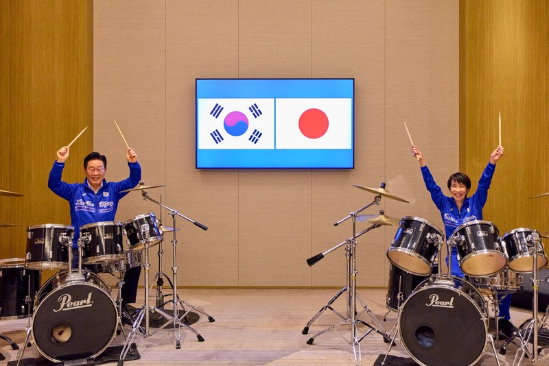 Perdana Menteri Jepang Sanae Takaichi dan Presiden Korea Selatan Lee Jae Myung berpose untuk foto sebelum memainkan drum setelah pertemuan mereka di Nara, Jepang, Selasa (13/1/2026). (Yonhap via REUTERS)