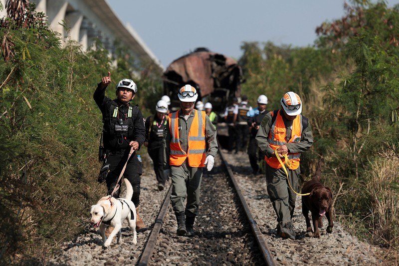 Para petugas bekerja di lokasi kecelakaan kereta api yang terjadi ketika sebuah derek konstruksi roboh dan jatuh menimpa gerbong-gerbongnya, menyebabkan beberapa korban jiwa, di distrik Sikhio, provinsi Nakhon Ratchasima, Thailand, 14 Januari 2026. (REUTERS/Chalinee Thirasupa)