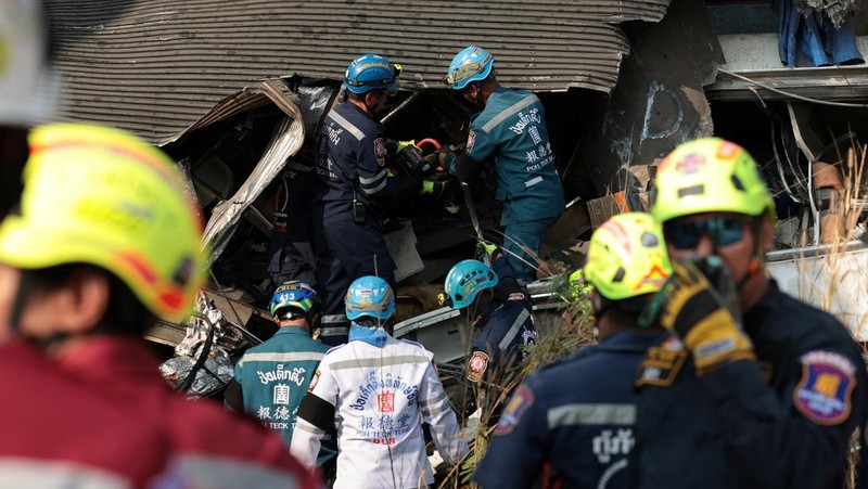 Para petugas bekerja di lokasi kecelakaan kereta api yang terjadi ketika sebuah derek konstruksi roboh dan jatuh menimpa gerbong-gerbongnya, menyebabkan beberapa korban jiwa, di distrik Sikhio, provinsi Nakhon Ratchasima, Thailand, 14 Januari 2026. (REUTERS/Chalinee Thirasupa)