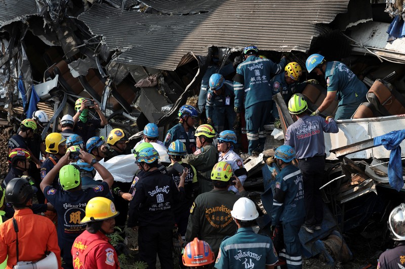 Para petugas bekerja di lokasi kecelakaan kereta api yang terjadi ketika sebuah derek konstruksi roboh dan jatuh menimpa gerbong-gerbongnya, menyebabkan beberapa korban jiwa, di distrik Sikhio, provinsi Nakhon Ratchasima, Thailand, 14 Januari 2026. (REUTERS/Chalinee Thirasupa)