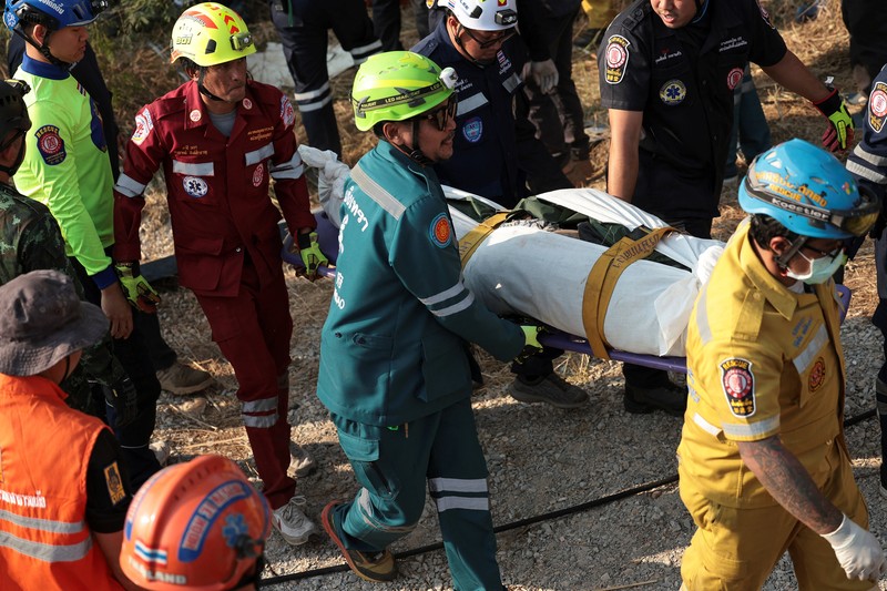 Para petugas bekerja di lokasi kecelakaan kereta api yang terjadi ketika sebuah derek konstruksi roboh dan jatuh menimpa gerbong-gerbongnya, menyebabkan beberapa korban jiwa, di distrik Sikhio, provinsi Nakhon Ratchasima, Thailand, 14 Januari 2026. (REUTERS/Chalinee Thirasupa)