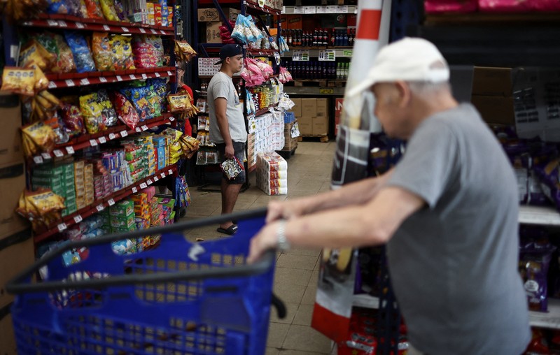 Para pembeli mengecek harga di sebuah supermarket di Villa Martelli di pinggiran Buenos Aires, Argentina, 13 Januari 2026. (REUTERS/Agustin Marcarian)