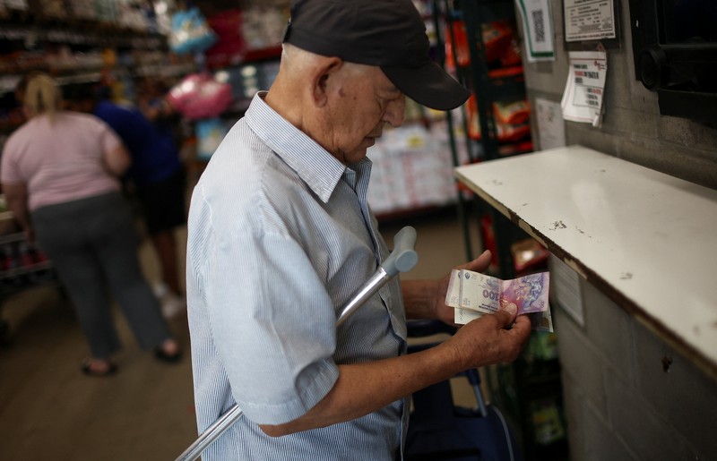 Para pembeli mengecek harga di sebuah supermarket di Villa Martelli di pinggiran Buenos Aires, Argentina, 13 Januari 2026. (REUTERS/Agustin Marcarian)