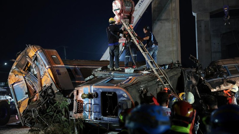 Petugas penyelamat mengangkat puing-puing di lokasi kecelakaan kereta api ketika sebuah derek konstruksi roboh dan menimpa gerbong-gerbongnya, menyebabkan beberapa korban jiwa, di distrik Sikhio, provinsi Nakhon Ratchasima, Thailand, 14 Januari 2026. (REUTERS/Chalinee Thirasupa)