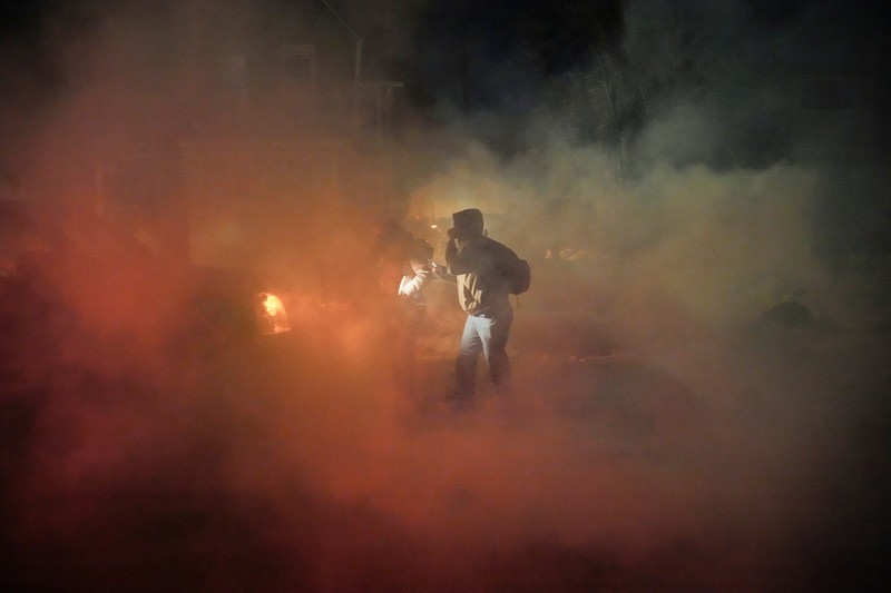 Para pengunjuk rasa berhadapan dan bentrok dengan pihak berwenang di Minneapolis utara dekat lokasi seorang pria ditembak di kaki pada Rabu (14/2/2026). (REUTERS/Ryan Murphy)
