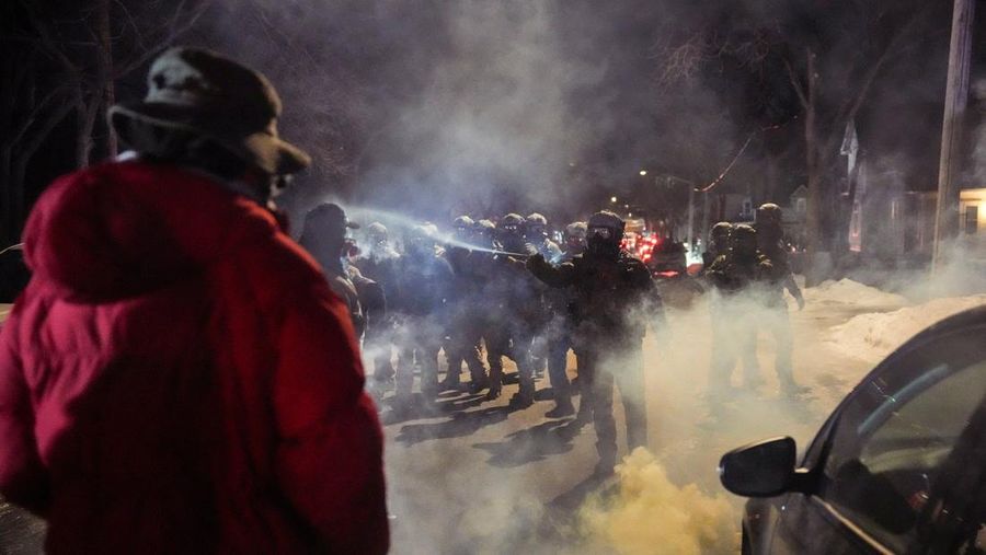 Para pengunjuk rasa berhadapan dan bentrok dengan pihak berwenang di Minneapolis utara dekat lokasi seorang pria ditembak di kaki pada Rabu (14/2/2026). (REUTERS/Ryan Murphy)