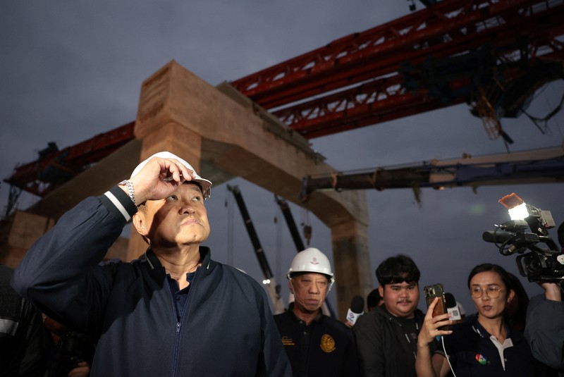 Petugas penyelamat mengangkat puing-puing di lokasi kecelakaan kereta api ketika sebuah derek konstruksi roboh dan menimpa gerbong-gerbongnya, menyebabkan beberapa korban jiwa, di distrik Sikhio, provinsi Nakhon Ratchasima, Thailand, 14 Januari 2026. (REUTERS/Chalinee Thirasupa)