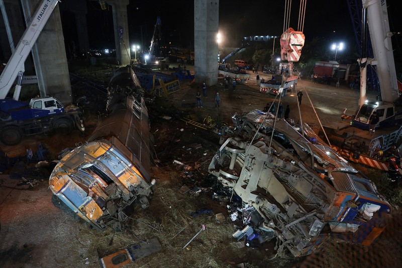 Petugas penyelamat mengangkat puing-puing di lokasi kecelakaan kereta api ketika sebuah derek konstruksi roboh dan menimpa gerbong-gerbongnya, menyebabkan beberapa korban jiwa, di distrik Sikhio, provinsi Nakhon Ratchasima, Thailand, 14 Januari 2026. (REUTERS/Chalinee Thirasupa)