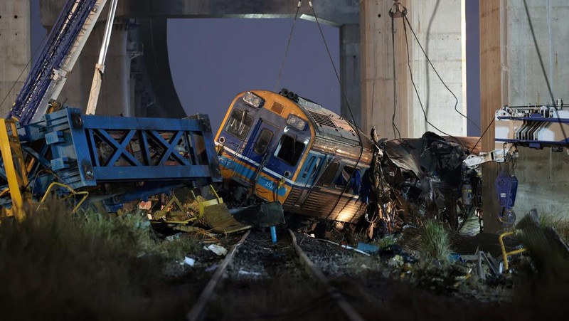 Petugas penyelamat mengangkat puing-puing di lokasi kecelakaan kereta api ketika sebuah derek konstruksi roboh dan menimpa gerbong-gerbongnya, menyebabkan beberapa korban jiwa, di distrik Sikhio, provinsi Nakhon Ratchasima, Thailand, 14 Januari 2026. (REUTERS/Chalinee Thirasupa)