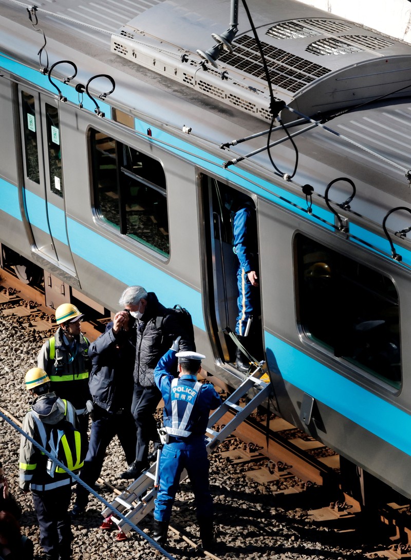 Penumpang dievakuasi dari kereta yang terhenti di jalur Keihin-Tohoku menuju stasiun Tamachi di Tokyo, Jepang, Jumat (16/1/2026). (REUTERS/Kim Kyung-Hoon)