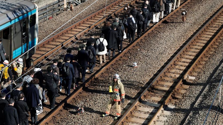 Penumpang dievakuasi dari kereta yang terhenti di jalur Keihin-Tohoku menuju stasiun Tamachi di Tokyo, Jepang, Jumat (16/1/2026). (REUTERS/Kim Kyung-Hoon)