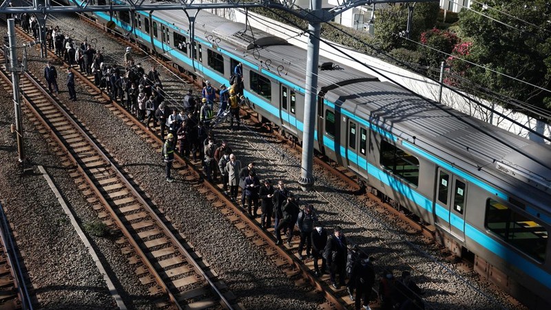 Penumpang dievakuasi dari kereta yang terhenti di jalur Keihin-Tohoku menuju stasiun Tamachi di Tokyo, Jepang, Jumat (16/1/2026). (REUTERS/Kim Kyung-Hoon)