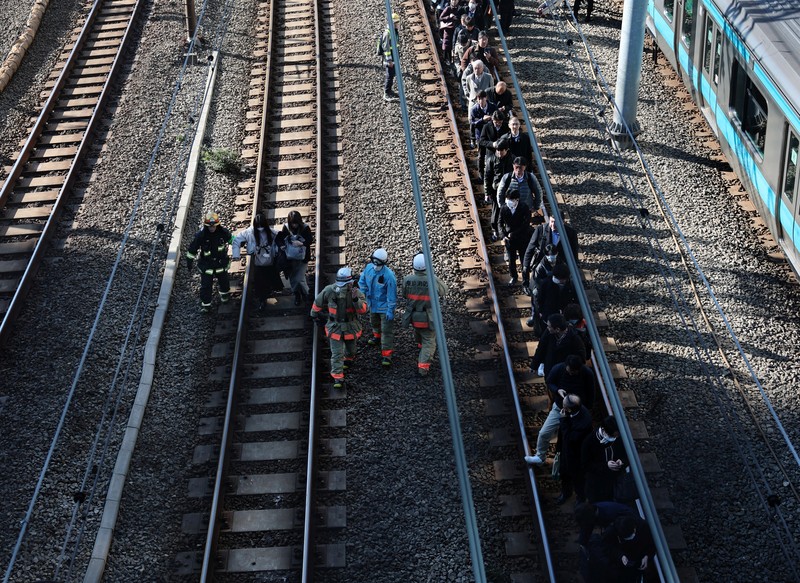 Penumpang dievakuasi dari kereta yang terhenti di jalur Keihin-Tohoku menuju stasiun Tamachi di Tokyo, Jepang, Jumat (16/1/2026). (REUTERS/Kim Kyung-Hoon)