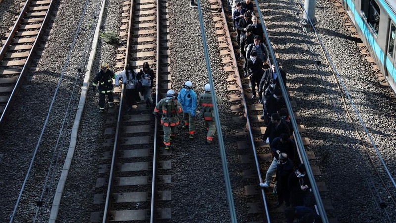 Penumpang dievakuasi dari kereta yang terhenti di jalur Keihin-Tohoku menuju stasiun Tamachi di Tokyo, Jepang, Jumat (16/1/2026). (REUTERS/Kim Kyung-Hoon)