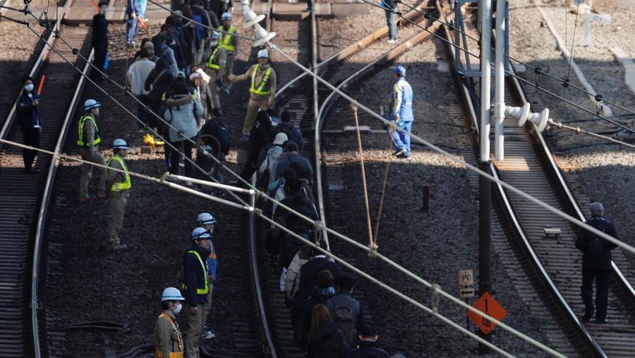 Penumpang dievakuasi dari kereta yang terhenti di jalur Keihin-Tohoku menuju stasiun Tamachi di Tokyo, Jepang, Jumat (16/1/2026). (REUTERS/Kim Kyung-Hoon)
