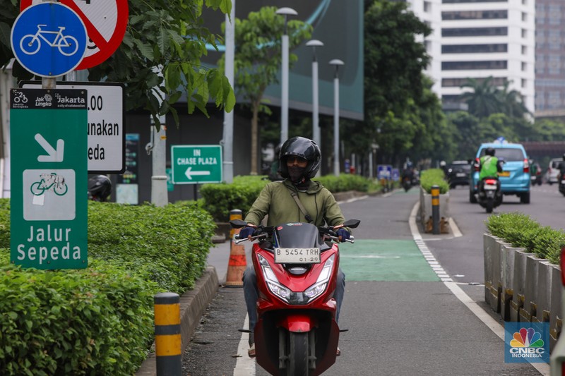Pengendara sepeda motor melintasi jalur sepeda di kawasan Sudirman, Jakarta (20/1/2026).  Jalur sepeda yang merupakan upaya Pemerintah Provinsi DKI Jakarta untuk mendorong penggunaan transportasi ramah lingkungan kerap di lalui pengendara sepeda motor pada jam sibuk maupun saat lengang.
