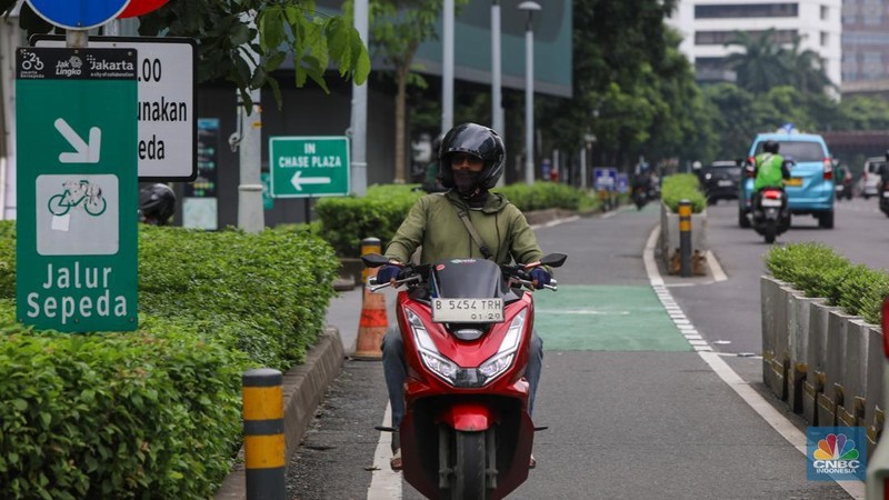 Pengendara sepeda motor melintasi jalur sepeda di kawasan Sudirman, Jakarta (20/1/2026).  Jalur sepeda yang merupakan upaya Pemerintah Provinsi DKI Jakarta untuk mendorong penggunaan transportasi ramah lingkungan kerap di lalui pengendara sepeda motor pada jam sibuk maupun saat lengang.