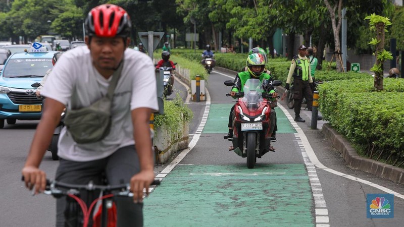 Pengendara sepeda motor melintasi jalur sepeda di kawasan Sudirman, Jakarta (20/1/2026).  Jalur sepeda yang merupakan upaya Pemerintah Provinsi DKI Jakarta untuk mendorong penggunaan transportasi ramah lingkungan kerap di lalui pengendara sepeda motor pada jam sibuk maupun saat lengang.