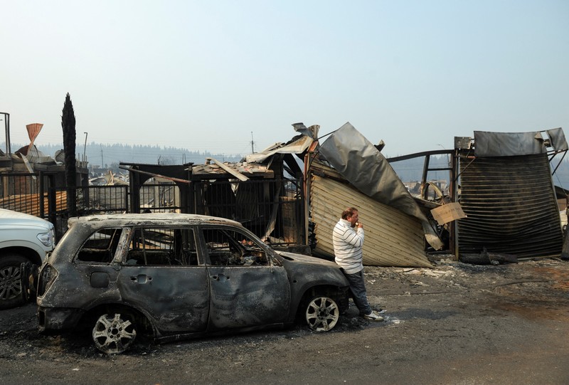 Sebuah tugu peringatan menandai lokasi di mana seseorang meninggal di masa lalu, di tengah tanah hangus setelah kebakaran hutan menghancurkan ratusan rumah, menewaskan beberapa orang dan memaksa evakuasi massal, sementara pihak berwenang terus berjuang melawan hampir dua lusin kobaran api yang diperparah oleh panas ekstrem dan angin kencang, di jalan antara Lirquen dan Punta de Parra, Chili, 19 Januari 2026. (REUTERS/Jose Luis Saavedra)