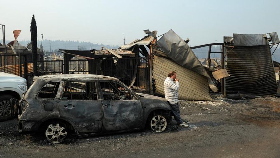 Sebuah tugu peringatan menandai lokasi di mana seseorang meninggal di masa lalu, di tengah tanah hangus setelah kebakaran hutan menghancurkan ratusan rumah, menewaskan beberapa orang dan memaksa evakuasi massal, sementara pihak berwenang terus berjuang melawan hampir dua lusin kobaran api yang diperparah oleh panas ekstrem dan angin kencang, di jalan antara Lirquen dan Punta de Parra, Chili, 19 Januari 2026. (REUTERS/Jose Luis Saavedra)