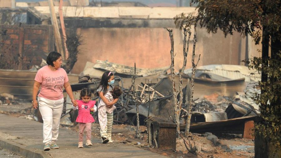 Sebuah tugu peringatan menandai lokasi di mana seseorang meninggal di masa lalu, di tengah tanah hangus setelah kebakaran hutan menghancurkan ratusan rumah, menewaskan beberapa orang dan memaksa evakuasi massal, sementara pihak berwenang terus berjuang melawan hampir dua lusin kobaran api yang diperparah oleh panas ekstrem dan angin kencang, di jalan antara Lirquen dan Punta de Parra, Chili, 19 Januari 2026. (REUTERS/Jose Luis Saavedra)