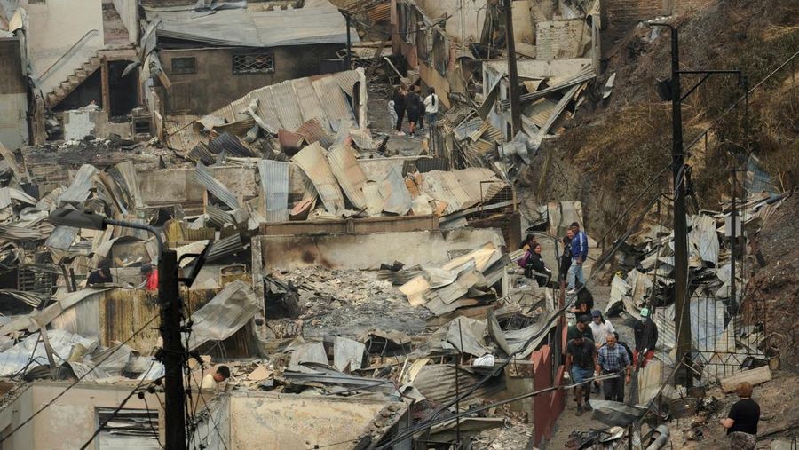 Sebuah tugu peringatan menandai lokasi di mana seseorang meninggal di masa lalu, di tengah tanah hangus setelah kebakaran hutan menghancurkan ratusan rumah, menewaskan beberapa orang dan memaksa evakuasi massal, sementara pihak berwenang terus berjuang melawan hampir dua lusin kobaran api yang diperparah oleh panas ekstrem dan angin kencang, di jalan antara Lirquen dan Punta de Parra, Chili, 19 Januari 2026. (REUTERS/Jose Luis Saavedra)