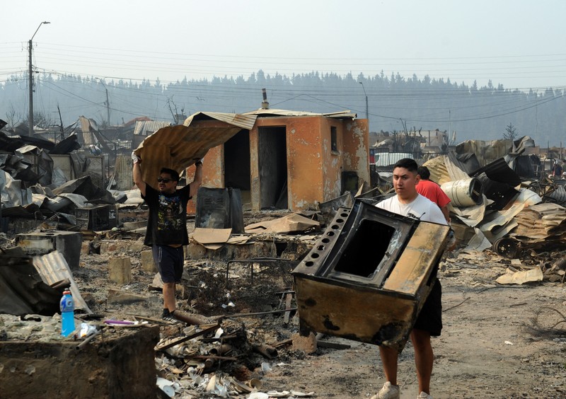 Sebuah tugu peringatan menandai lokasi di mana seseorang meninggal di masa lalu, di tengah tanah hangus setelah kebakaran hutan menghancurkan ratusan rumah, menewaskan beberapa orang dan memaksa evakuasi massal, sementara pihak berwenang terus berjuang melawan hampir dua lusin kobaran api yang diperparah oleh panas ekstrem dan angin kencang, di jalan antara Lirquen dan Punta de Parra, Chili, 19 Januari 2026. (REUTERS/Jose Luis Saavedra)